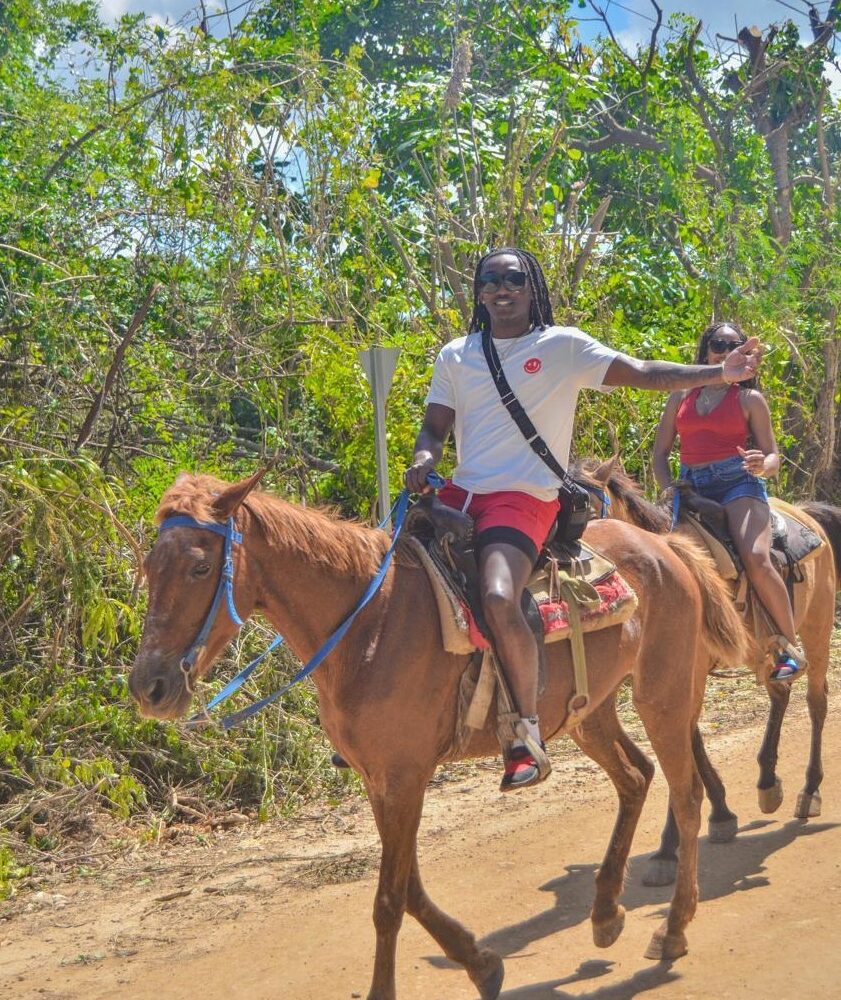 Tourists horseback riding through tropical forest on Punta Cana tour with taxiboat operator