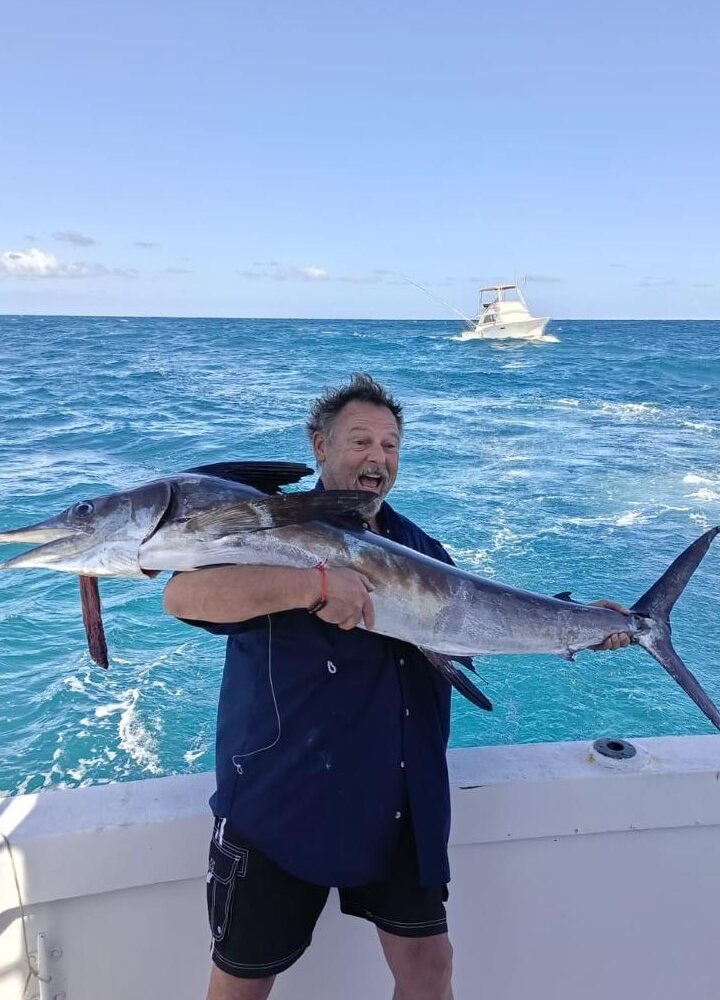 Taxiboat Punta Cana fishing tour - man holding large caught fish on boat in Caribbean waters