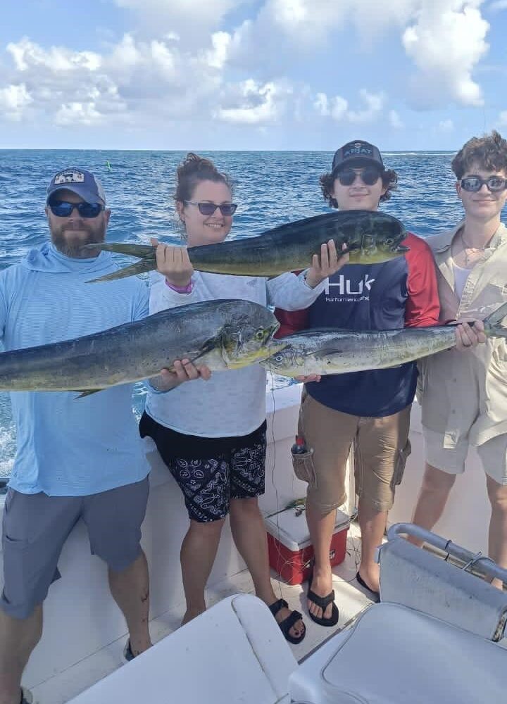 Group of tourists holding fresh caught fish on a taxiboat tour in Punta Cana with ocean and blue sky