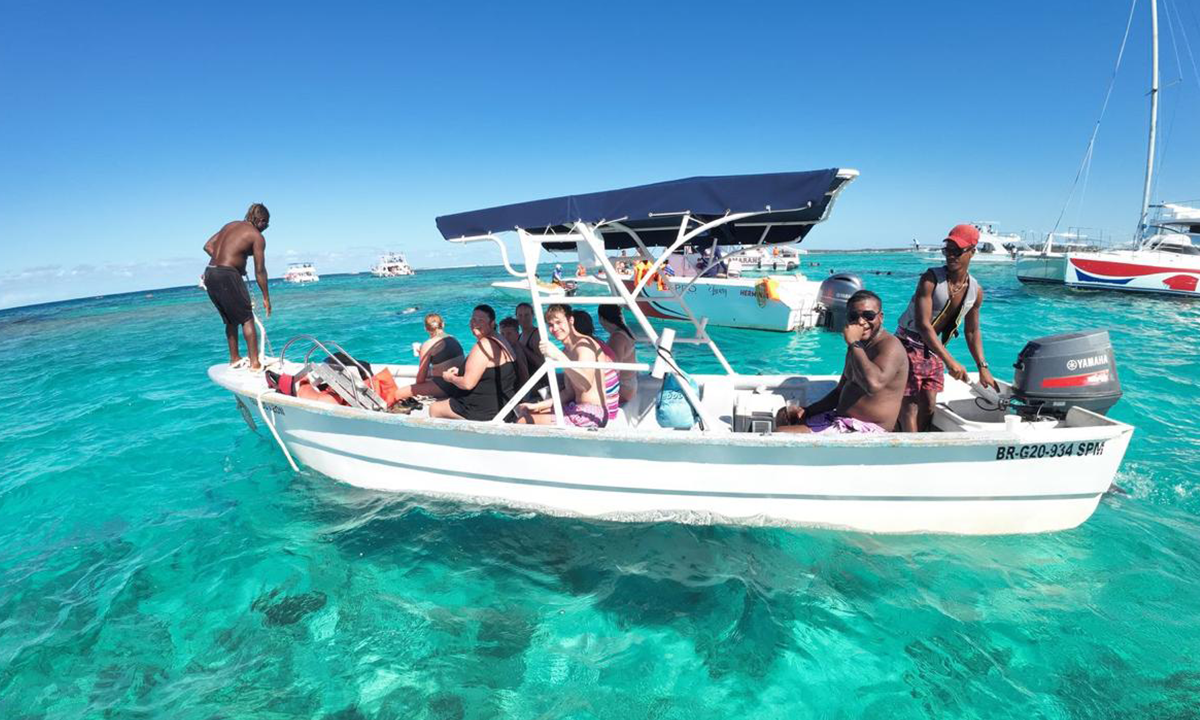 Taxiboat Punta Cana tour with tourists in turquoise Caribbean waters, professional boat service for best Punta Cana tours