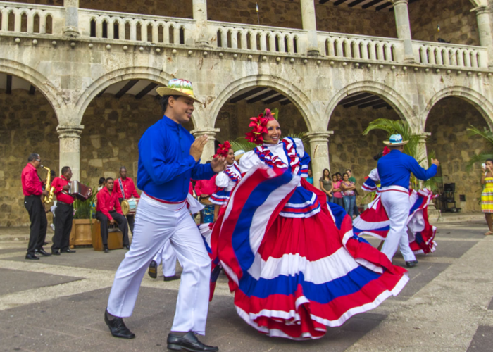 Traditional Dominican dancers performing at historic colonial architecture during Punta Cana cultural tour experience